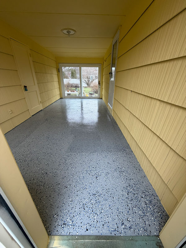 Finished epoxy floor installation with flake finish in enclosed porch area