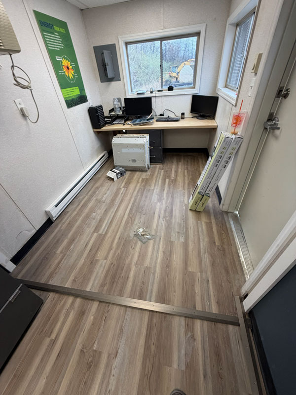 Remodeled shipping container office interior with new flooring, finished walls, and workspace area