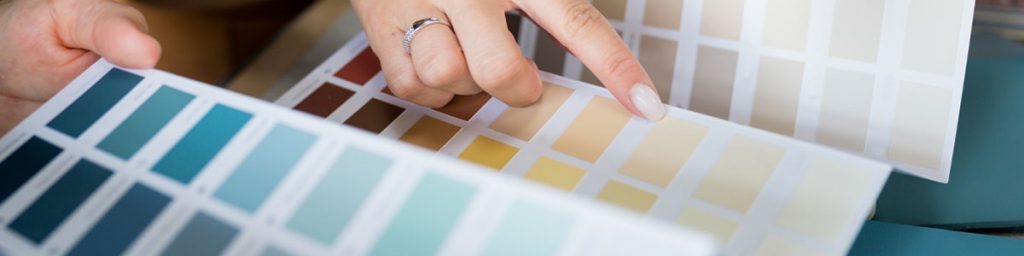 Homeowner reviewing interior paint color samples to choose paint colors for a house interior painting project
