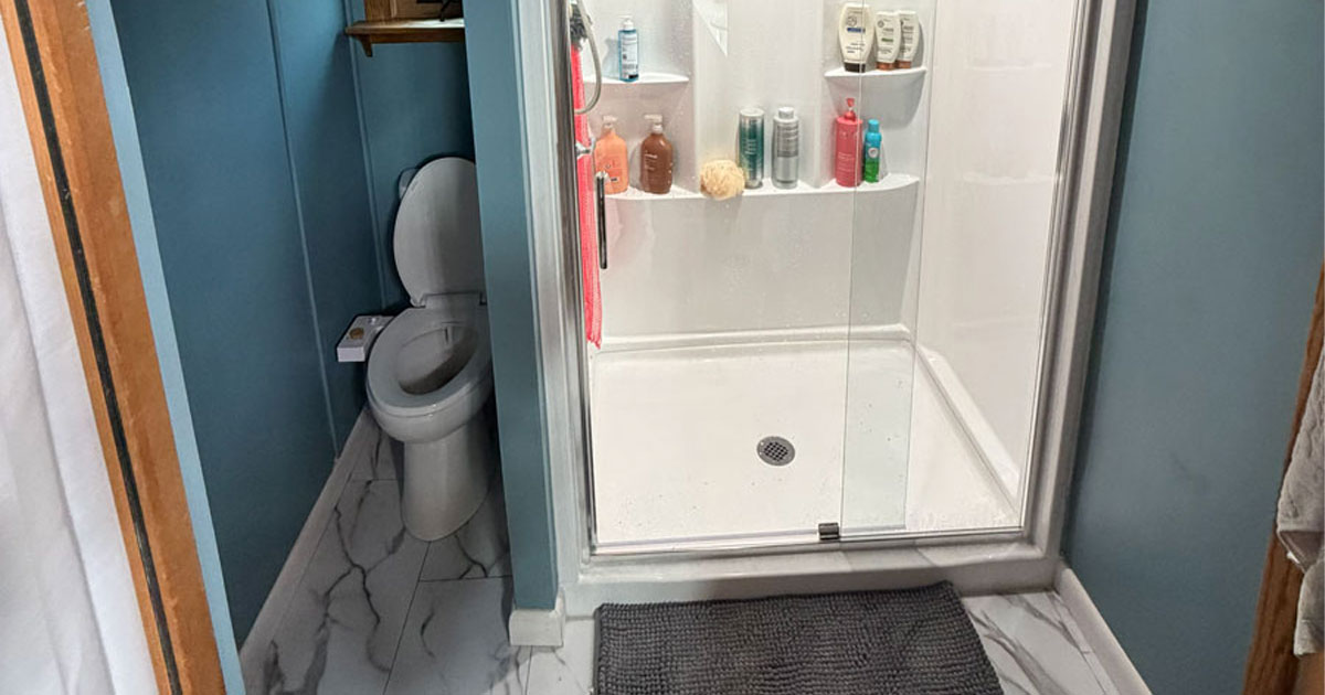Full bathroom remodel featuring a custom walk-in shower with glass enclosure, marble-look tile flooring, updated fixtures, and modern finishes by White Pine Builds.