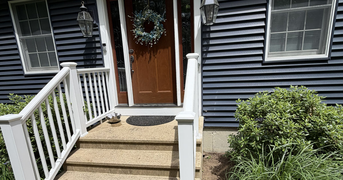 Front entry with newly installed white vinyl railings on existing concrete steps