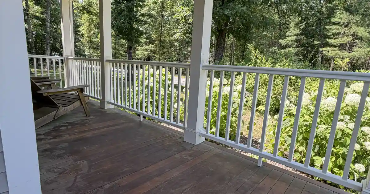 white deck railing wood porch forest view