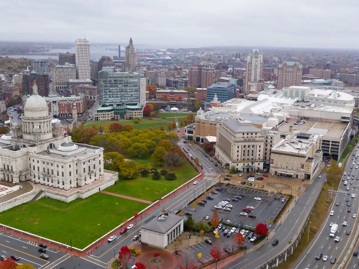 Aerial view of a downtown skyline with a domed capitol and fall foliage.