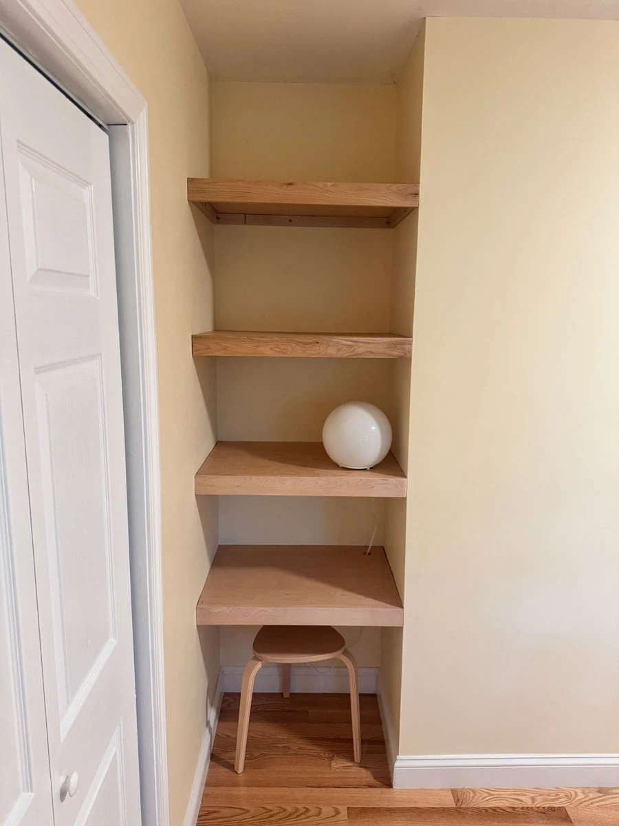 Custom built-in basement shelving and workspace nook designed for organized storage and a functional finished basement.