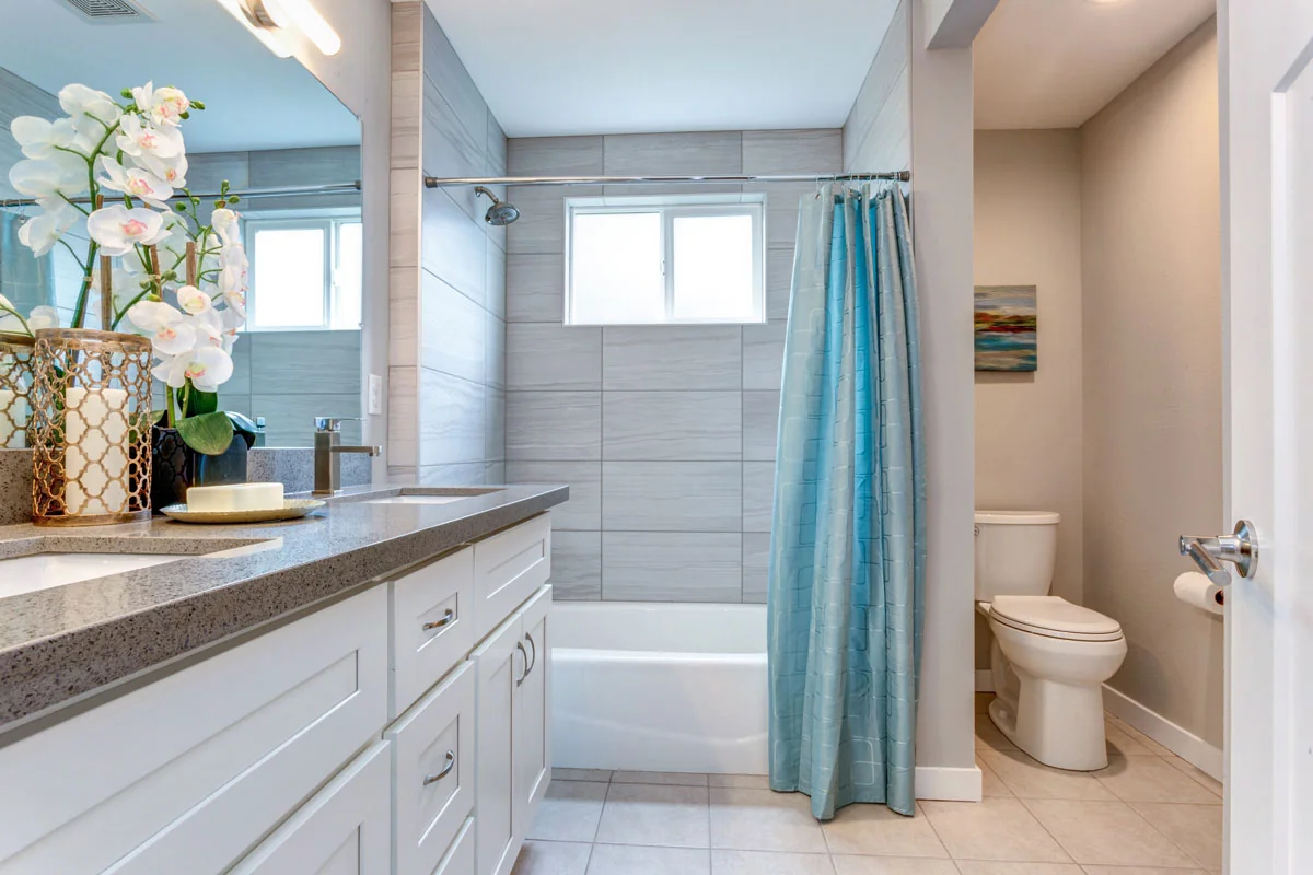 Bathroom remodeling Worcester MA featuring a custom bathroom vanity, bathtub and shower combination, tile flooring, and modern fixtures.