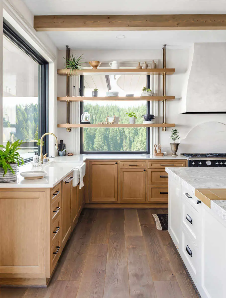Remodeled kitchen with wood cabinetry, open shelving, marble countertops, and a wood beam ceiling