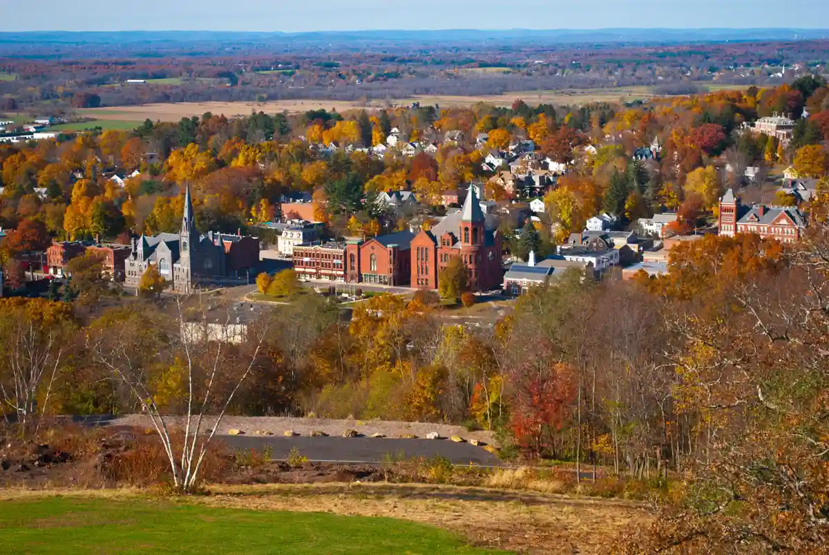 Aerial view of a Tolland County, Connecticut town center with fall foliage and historic brick buildings